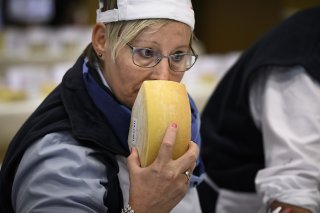 Un membre du jury en train de humer un fromage dans le cadre d'un concours.